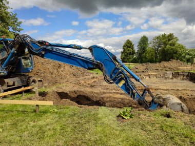 Bir binanın temeli için hendek kazan bir kazıcı.
