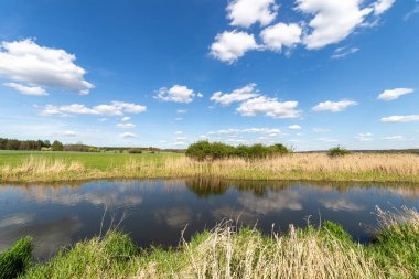 Mavi gökyüzü açık mavi nehrin üzerindeki bulutlarla.