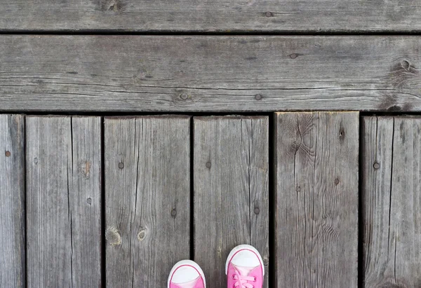 Zapatos rosados en una pasarela de madera vieja — Foto de Stock