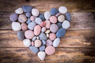 Stone heart on a wooden background clipart