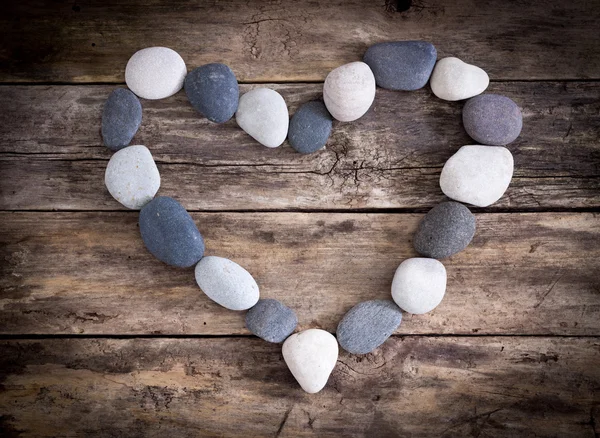 Stone heart on a wooden background — Stock Photo, Image