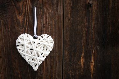 Ahşap arka plan üzerinde beyaz hasır kalp