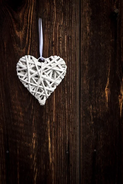 Coração de vime branco no fundo de madeira — Fotografia de Stock