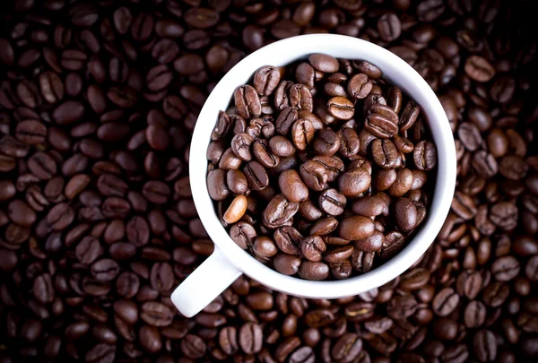 Кофейные зерна в кофейной чашке. Макро крупным планом . — стоковое фото