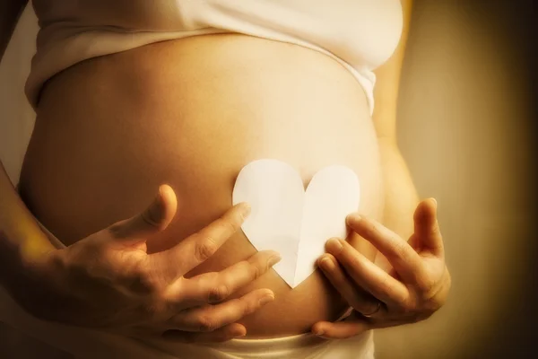 Baby bump with paper heart — Stock Photo, Image