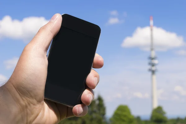 Telefone celular e torre de transmissão — Fotografia de Stock