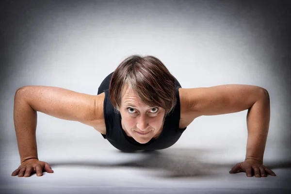 Mujer de mediana edad haciendo flexiones Fotos De Stock Sin Royalties Gratis