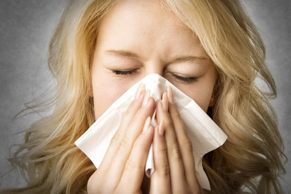 Ill woman with tissue is sneezing Royalty Free Stock Photos