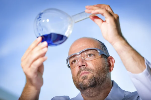 Chemist with blue liquid — Stock Photo, Image