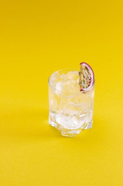 Bir bardak su, bir dilim tutku meyvesi ve buz.