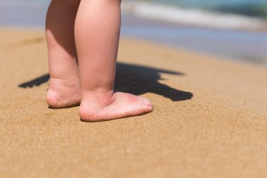 Bebe ayak üzerinde kum plaj yürüyüş