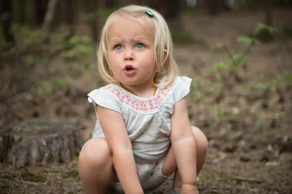 Malá holčička hraje v lese — Stock fotografie