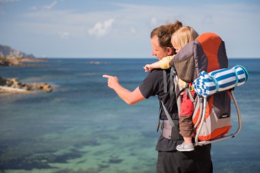 Baba ve bebek sırt çantası taşıyıcıya açık havada denize yakın