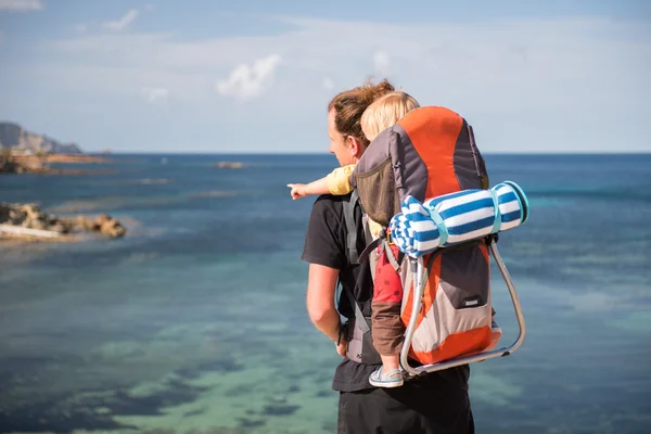 Padre y bebé en mochila al aire libre cerca del mar —  Fotos de Stock