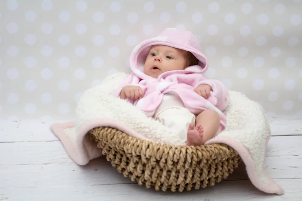 Cute baby girl sitting in a basket — Stock Photo, Image