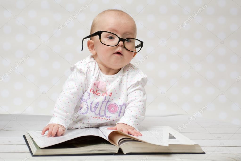 Funny baby girl reading a book Stock Photo by ©KamilaStarzycka 67921229