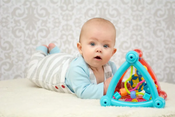 Olhos azuis bebê brincando com brinquedo — Fotografia de Stock