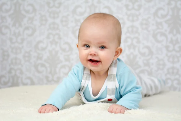 Niedliches kleines Baby mit blauen Augen, das in die Kamera lächelt — Stockfoto