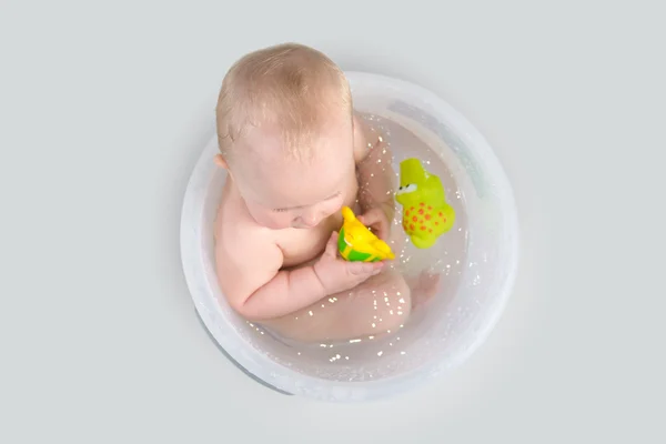 Draguta copil having o baie în găleată transparentă și joc cu jucării — Fotografie, imagine de stoc