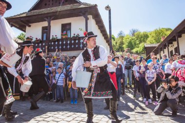 HOLLOKO, HUNGARY - 12 Nisan 2019 Paskalya Festivali Macaristan 'ın Holloko kasabasında. Erkekler kızların üzerine su serper.