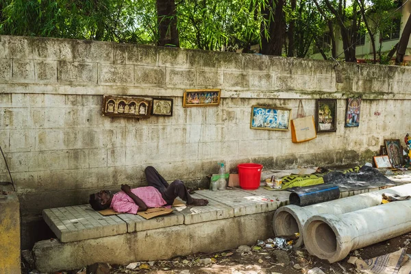 Bangalore, India - 04 de mayo de 2020: Homeless man sleeps on the sidewalk on the street of Bangalore, India. Mucha gente pobre en la India — Foto de Stock