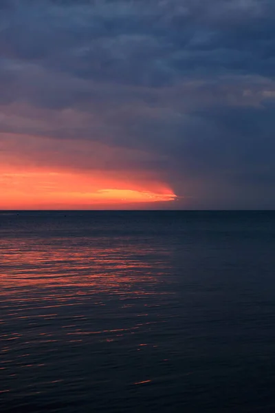 Невероятно красивый закат. Солнце уходит в море и окрашивает небо ярко-оранжевым цветом. — стоковое фото