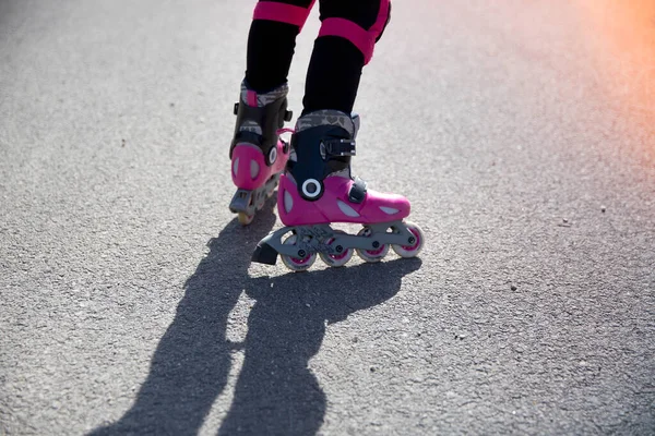 Close-up van de benen van een meisje op rolschaatsen en bescherming voor de benen, kniebeschermers — Stockfoto