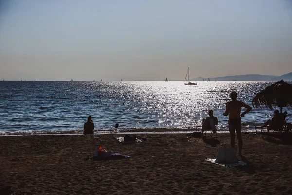 People silhouettes on the beach on sunset time, Hello summer concept — стоковое фото