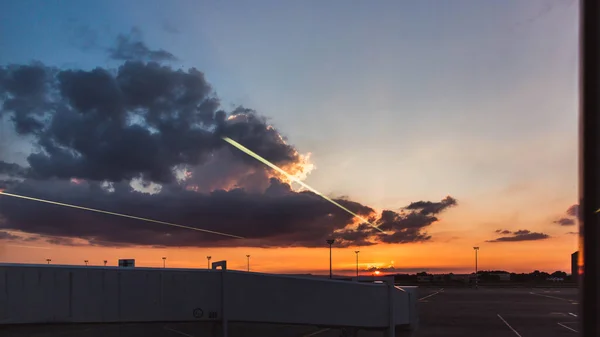 明るい日没で空港のターミナルの近くの飛行機 — ストック写真