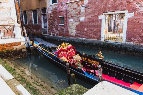 Tradicional góndola decorada en rojo y dorado en un canal verde de Venecia, Italia — Foto de Stock