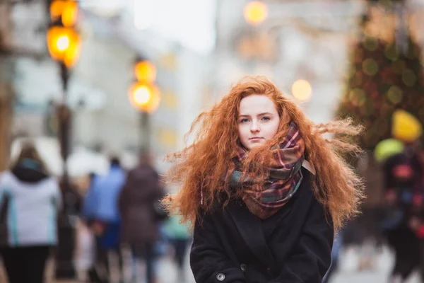 Vörös hajú lány élvezi az Európai Karácsonyi Piacot. Homályos fények karácsonyfán a háttérben — Stock Fotó