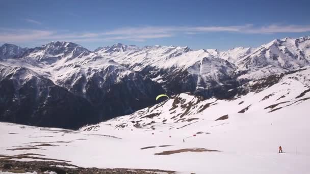 Paralotniarski start. Osoba startująca z paralotnią na śnieżnej górze w Alpach — Wideo stockowe