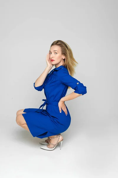 Mulher bonita posa para a câmera em bluedress isolado no fundo branco — Fotografia de Stock