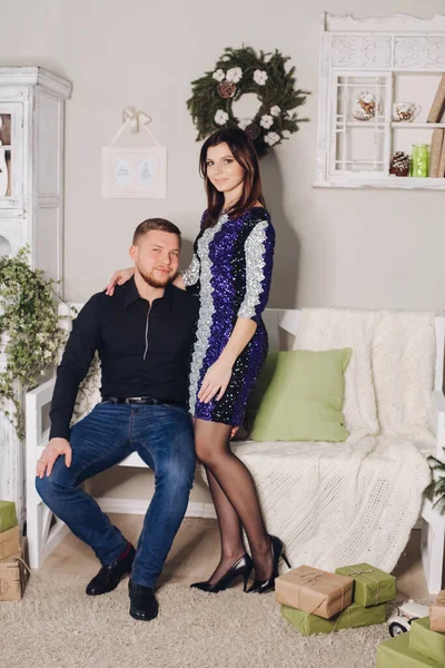 Retrato de jovem casal bonito apaixonado com roupas bonitas posando para uma sessão de fotos de Ano Novo em casa — Fotografia de Stock