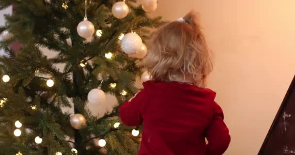 Dítě hraje s vánoční stromeček dekorace. — Stock video