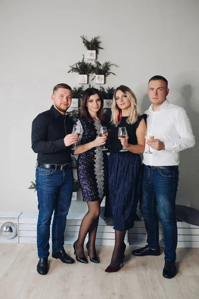 A companhia caucasiana engraçada de amigos caucasianos jovens celebra o Natal em conjunto na bela roupa — Fotografia de Stock