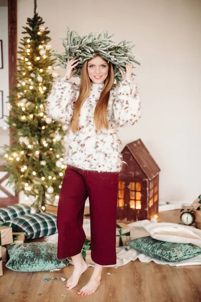 Beautiful barefoot woman in a head- wreath near Christmas tree — Stock Photo, Image