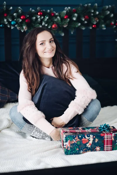 Vacker ung kvinna poserar nära en inslagen present — Stockfoto