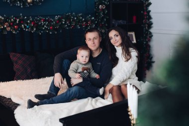 Küçük bir çocuğu olan neşeli bir aile birlikte eğleniyor.