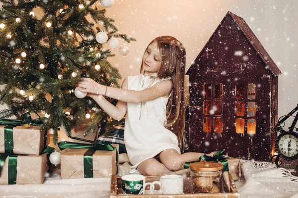 크리스마스 트리를 눈 속에 장식하는 소녀. — 스톡 사진
