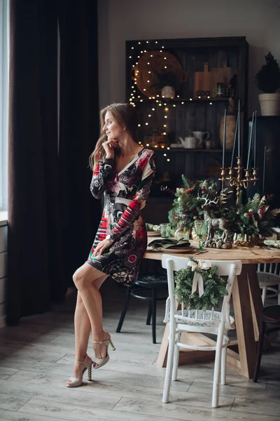 크리스마스에 식탁에 앉을 수있는 여성. 여성을 중상하고 Xmas 에서 옷을 입음. — 스톡 사진