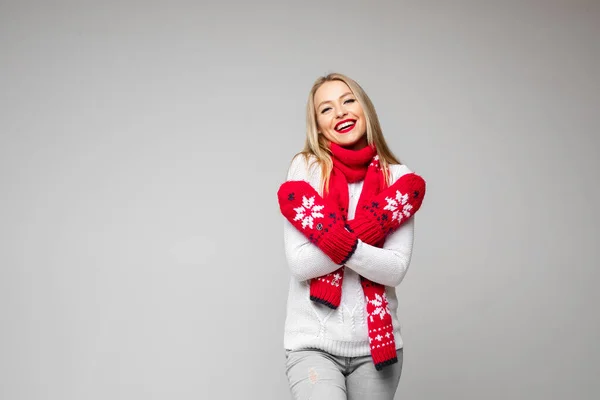Atractiva mujer en suéter blanco, bufanda roja y mitones rojos sonrisas — Foto de Stock