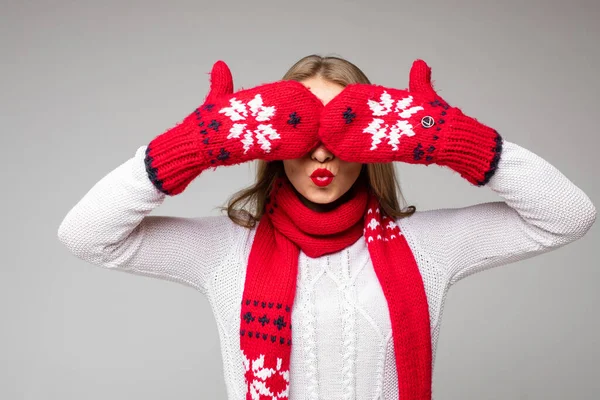 Menina cobrindo os olhos com luvas de inverno. Isolar em cinzento. — Fotografia de Stock