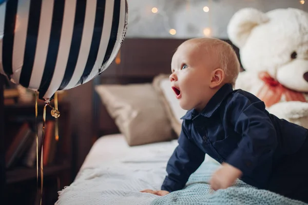 Kleine mooie jongen ligt op het bed — Stockfoto