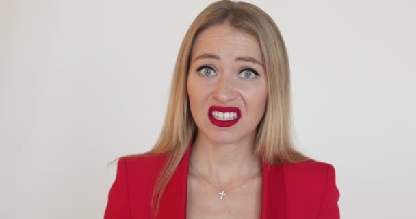 Ušklíbající se blondýna žena v červené bundě. — Stock video