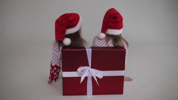 Šťastné holčičky v Santa klobouky baví na Štědrý večer — Stock video