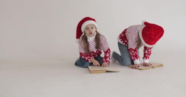 Ευτυχισμένα κορίτσια με ζεστά πουλόβερ στο πάτωμα στο στούντιο την παραμονή των Χριστουγέννων — Αρχείο Βίντεο
