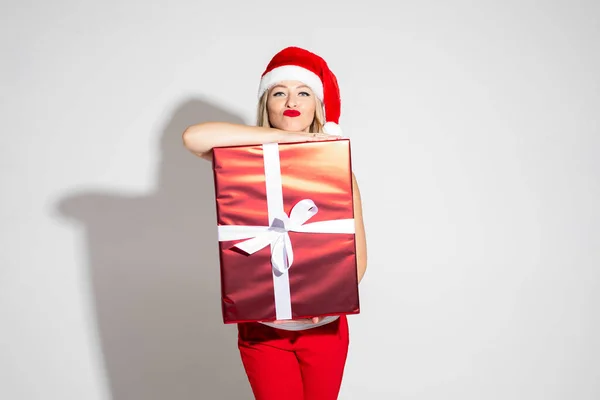 Hermosa mujer haciendo pucheros labios y posando con regalo de Navidad — Foto de Stock