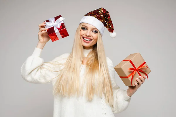 Piękna dziewczyna z dwoma prezentami świątecznymi uśmiechnięta do kamery. — Zdjęcie stockowe