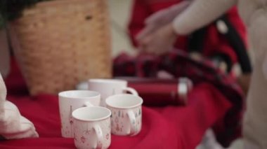 Kadın eldivenlerini çıkarıp termosu açıyor..